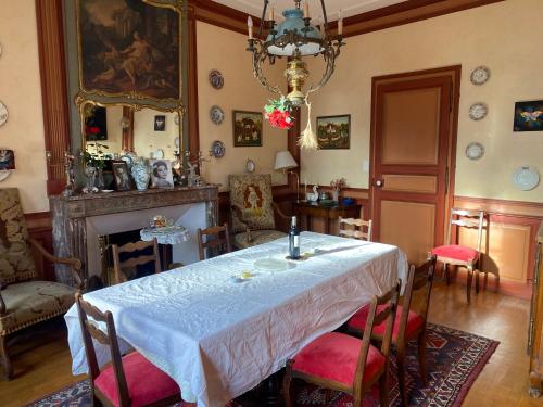 comedor con mesa y chimenea en La Grande maison, en Chambon-sur-Voueize