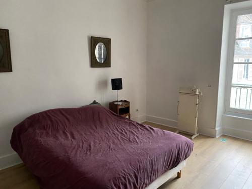 1 dormitorio con 1 cama con manta morada en La Grande maison, en Chambon-sur-Voueize