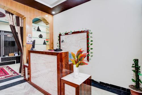 a lobby with a counter with a vase of flowers at Yoga Homestay in Agra