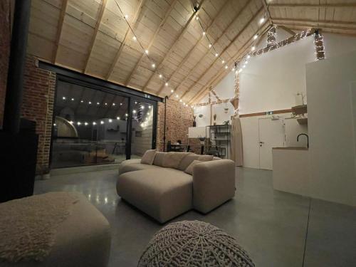 a living room with a couch and a kitchen at Boven de paarden @ de Hoeveschuur in Riemst