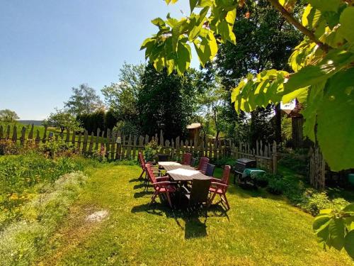 une table et des chaises dans une cour avec une clôture dans l'établissement Ferienhaus Jutta, à Stadtsteinach