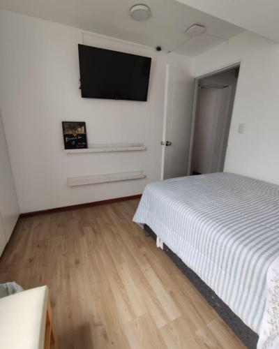 sypialnia z łóżkiem i telewizorem z płaskim ekranem w obiekcie La Habitación de Isolina w mieście Lima