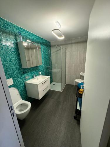 a bathroom with a toilet and a sink and a shower at Livly Apartment by Nature in Schattdorf