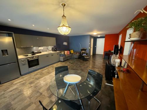 a kitchen with a glass table and chairs in a room at Livly Apartment by Nature in Schattdorf