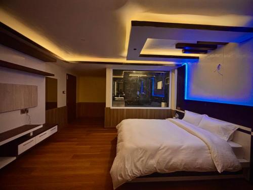 a bedroom with a white bed and a blue light at Pine Tree Resort in Bhaktapur