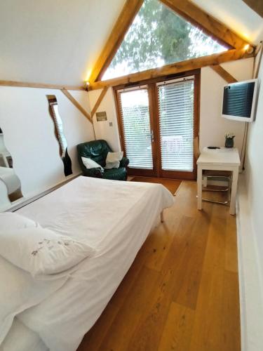 a bedroom with a large bed and a window at Prestwick House - Sleeps 10+ - Main House & 3 Separate Oak Framed Barn Studios - Rural in Chiddingfold