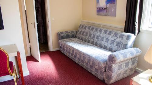 a living room with a couch in the corner at A Hotels Roskilde in Hedehusene