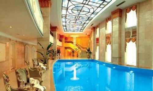 a large swimming pool in a building with a ceiling at Zhuhai Dehan Hotel in Zhuhai