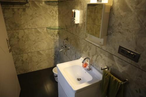 y baño con lavabo, espejo y aseo. en Skyview Villa Udaipur, en Udaipur