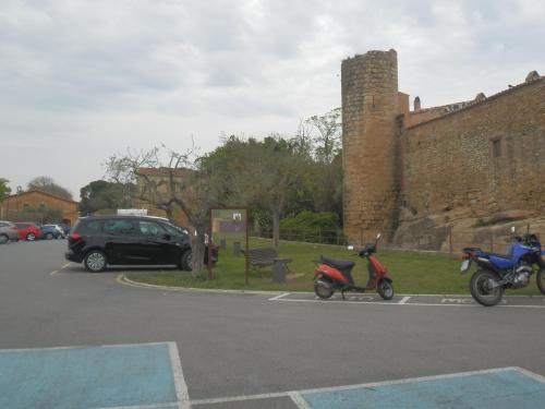 zwei Motorräder auf einem Parkplatz neben einem Schloss geparkt in der Unterkunft Empordà Apartamento- Peratallada in Peratallada