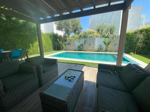 un patio amueblado y una piscina en Belle maison à proximité de la mer en La Marsa