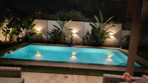Belle maison à proximité de la mer في المرسى: حمام سباحة في حديقة خلفية مع نباتات الفخار