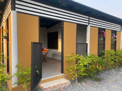 une maison à la façade noire et jaune dans l'établissement สวนชะลอม, à Ban Ton Chuak