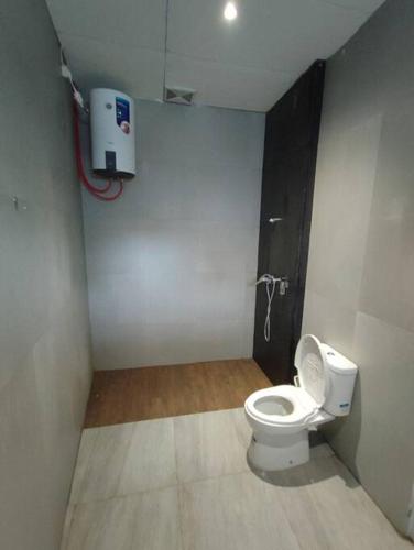 a bathroom with a white toilet in a stall at Jardine Villa 002 in Babakan Madang