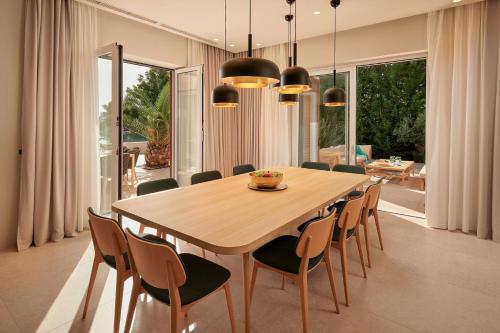 a dining room with a wooden table and chairs at Beautiful Villa Crystalsea 2 with a pool in Hvar in Hvar