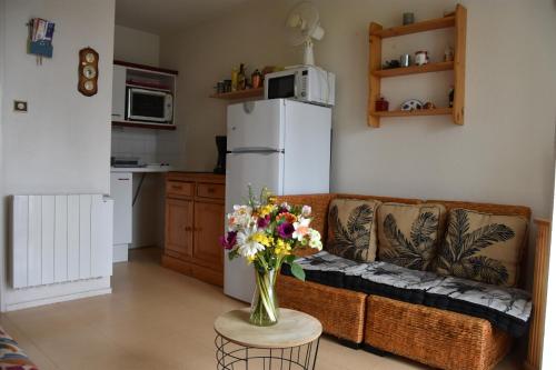 - un salon avec un canapé et un vase de fleurs dans l'établissement Appartement 1 chambre, avec loggia et vue sur le Port Olona, à La Chaume