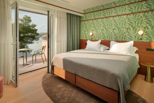 a bedroom with a bed and a balcony at Beautiful Villa Crystalsea 2 with a pool in Hvar in Hvar