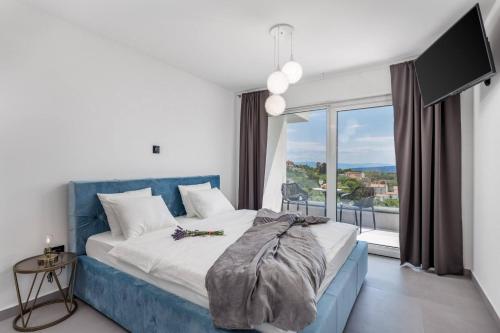 sypialnia z niebieskim łóżkiem i dużym oknem w obiekcie Luxury Villa Amataa - 38m2 pool, jacuzzi, sauna w mieście Mošćenička Draga