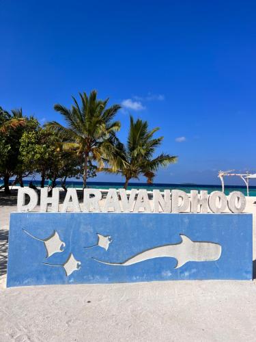a sign on the beach in front of the ocean at Biosphere Inn in Dharavandhoo