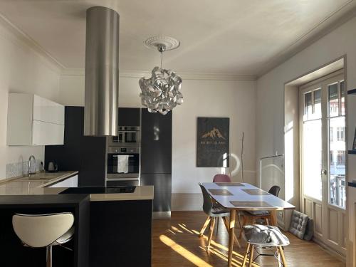 une cuisine avec une table et un lustre dans l'établissement Annecy ArtDeco Building, à Annecy