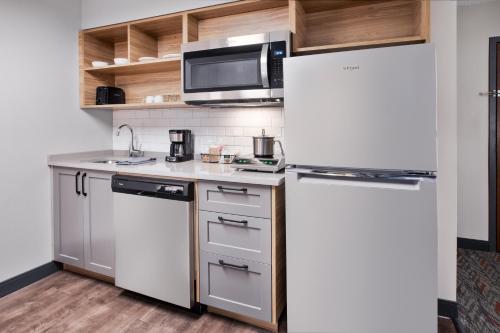 a kitchen with a refrigerator and a microwave at Candlewood Suites - Cincinnati Northeast - Mason by IHG in Mason