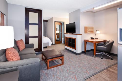 Habitación de hotel con sofá, escritorio y TV en Candlewood Suites - Cincinnati Northeast - Mason, an IHG Hotel, en Mason