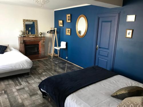 a blue bedroom with a bed and a mirror at L'hostellerie de Sèvremont in Saint-Michel-Mont-Mercure