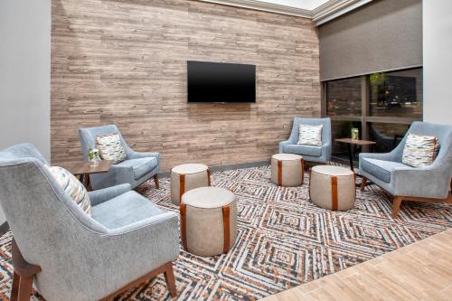 a lobby with three chairs and a flat screen tv at Candlewood Suites - Cincinnati Northeast - Mason by IHG in Mason