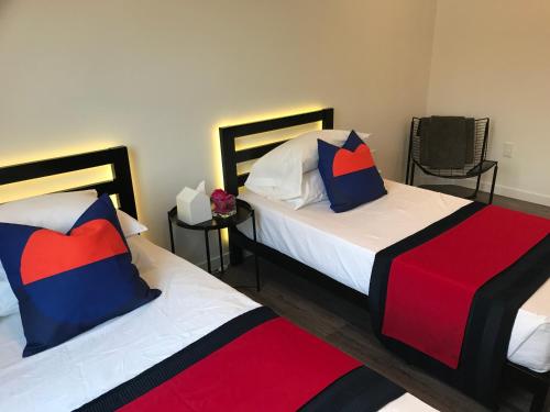 a bedroom with two beds and two chairs at Modern GuestHouse Ironbound Newark with KITCHEN-FastTrainToNYC-OneStopToAirport in Newark