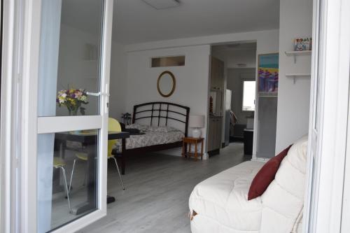 uma sala de estar com um sofá branco e uma mesa em Les Grandes Roches - Studio et balcon plage à pied em La Rudelière