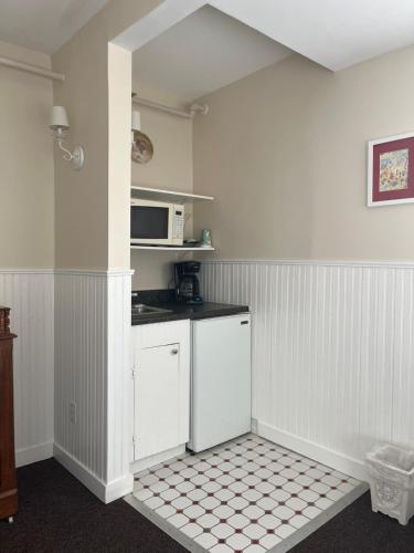 a kitchen with white cabinets and a microwave at Terrace Inn and 1911 Restaurant in Petoskey