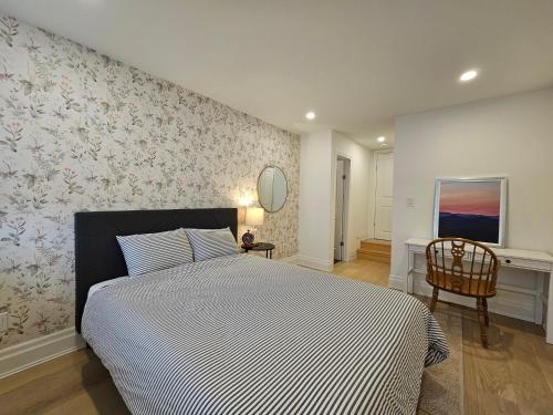 een slaapkamer met een groot bed en een stoel bij Private apartment with garden, 25 min to Downtown in Toronto