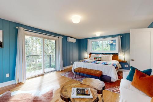 1 dormitorio con paredes azules, 1 cama y 1 sofá en Thunder Ranch, en Lake Oswego