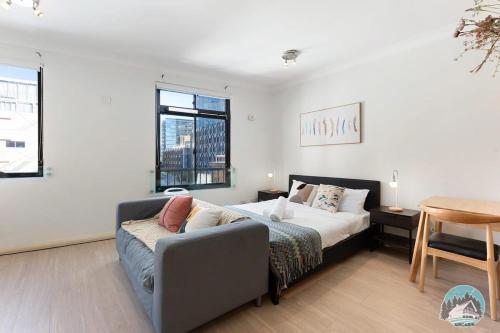 a bedroom with a bed and a couch and a table at Aircabin - Sydney Central Station - 1 Bed Studio in Sydney