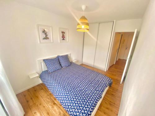 une petite chambre avec un lit avec une couette bleue dans l'établissement Disneyland Appart Rêve enfant, à Montévrain