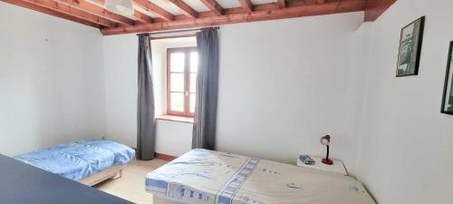Cette chambre comprend 2 lits et une fenêtre. dans l'établissement La clef des chants, à Longueville