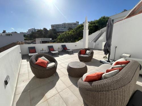 a patio with couches and chairs on a roof at Boutique Style Town House in Albufeira