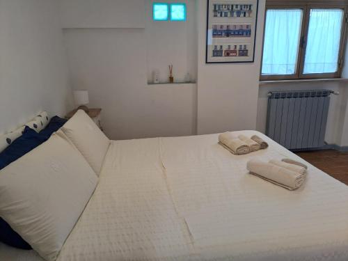 a white bed with two towels on top of it at Casa Susy in Rome
