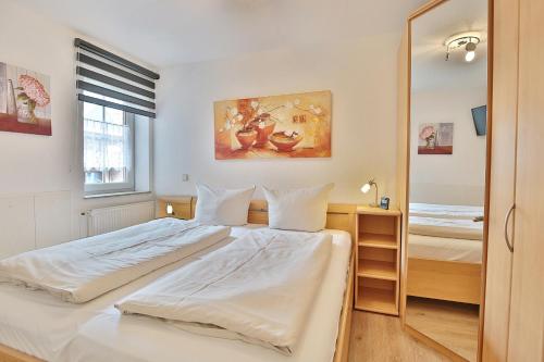 een slaapkamer met een groot wit bed en een spiegel bij Residenz Alte Bergstraße Residenz Alte Bergstrasse Appartement 9 in Scharbeutz