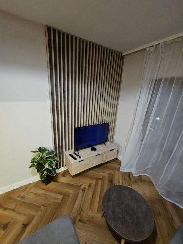 a living room with a tv and a table at Apartament B6 Green Resort z Basenem, Sauną, Jacuzzi - 5D Apartments in Szklarska Poręba