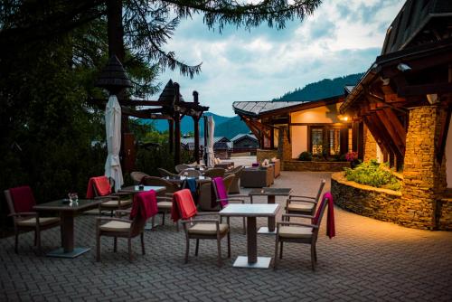 a patio with tables and chairs and a building at Šport Hotel *** Donovaly in Donovaly