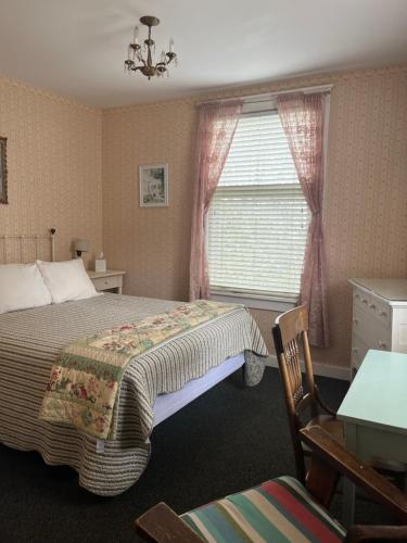 a bedroom with a bed and a window at Terrace Inn and 1911 Restaurant in Petoskey
