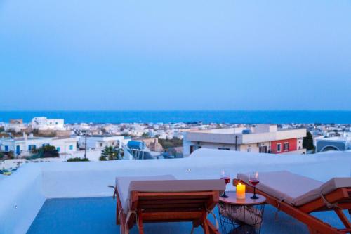 a balcony with a table and a view of a city at Elegant Cycladic Villa in Emporio Santorini