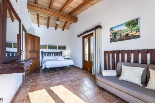 a bedroom with two beds and a couch in a room at Finca Sa Torreta in Santa Margalida