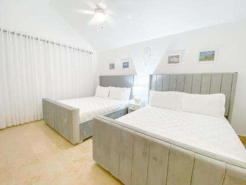 two beds in a room with white walls at Xeliter Green One Playa Dorada in San Felipe de Puerto Plata