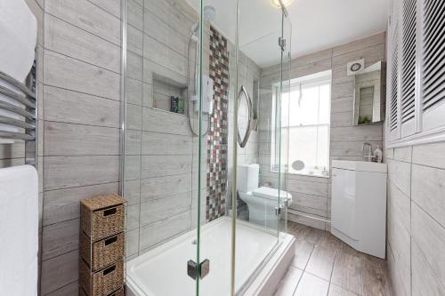 a bathroom with a shower and a tub and a toilet at Viking Bay View 3 Bed Apartment in Broadstairs