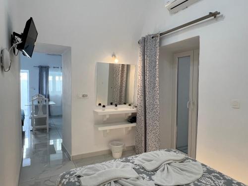 a white bathroom with a sink and a bed at Villa Pavlina in Karterados