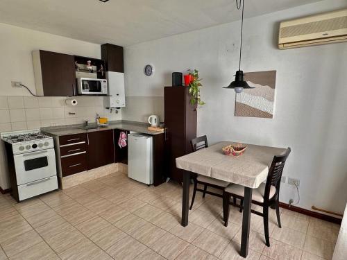 una pequeña cocina con mesa, mesa y sillas en Departamento macrocentro amueblado en Río Cuarto
