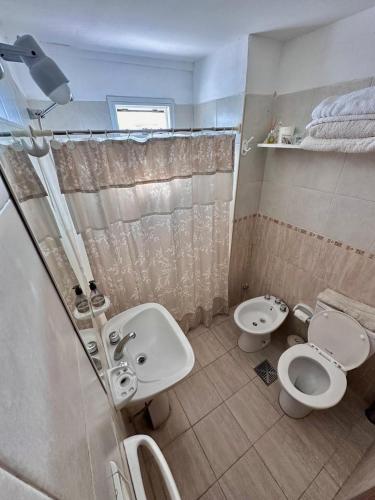 y baño con 2 aseos, lavamanos y ducha. en Departamento macrocentro amueblado en Río Cuarto