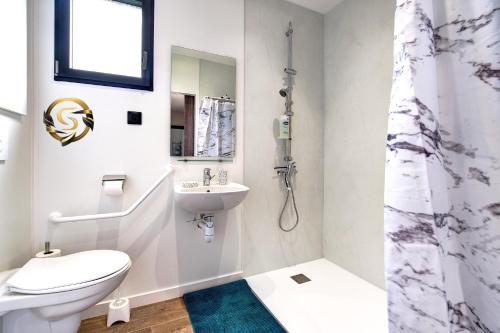 biała łazienka z toaletą i umywalką w obiekcie Tiny House Saint Cyr sur Menthon w mieście Saint-Cyr-sur-Menthon